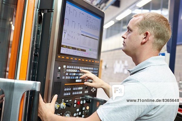 Worker looking at computer monitor in engineering factory