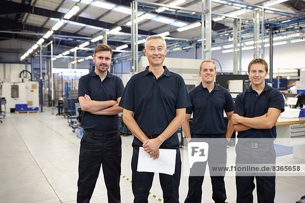 Portrait of four workers in engineering factory