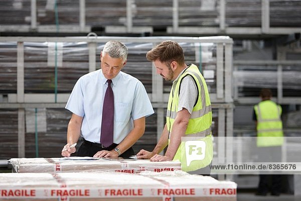 Warehouse worker and manager checking order in engineering warehouse