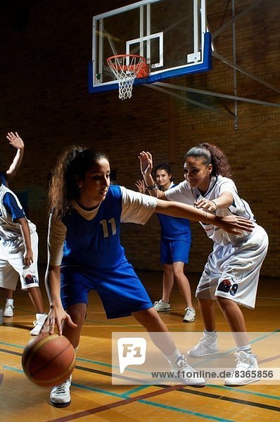 Basketball player defending opponent