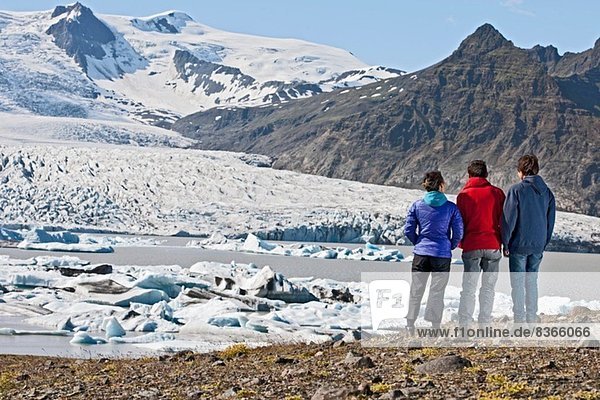 Drei Leute bewundern Fjallsarlon Lagune Skaftafell Island