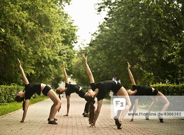 Vier junge Balletttänzer trainieren im Park