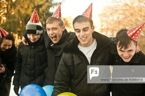 Gruppe junger Freunde mit Partyhüten