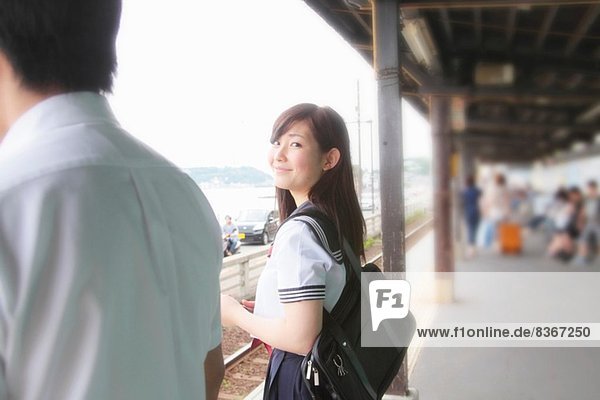 Junge Frau auf dem Bahnsteig mit Blick auf die Kamera