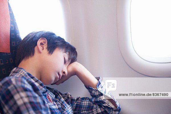 Boy asleep on aeroplane