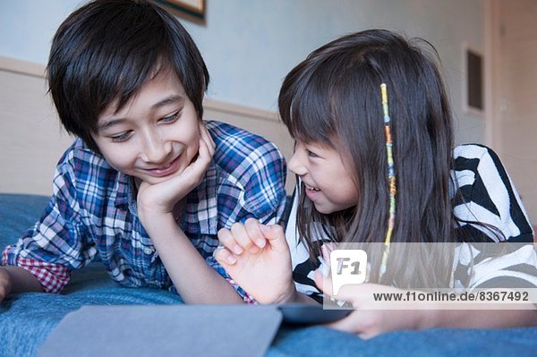 Bruder und Schwester mit digitaler Tablette