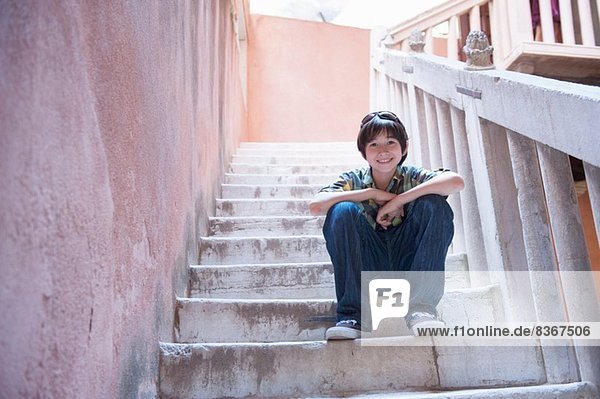 Junge sitzt auf einer Treppe