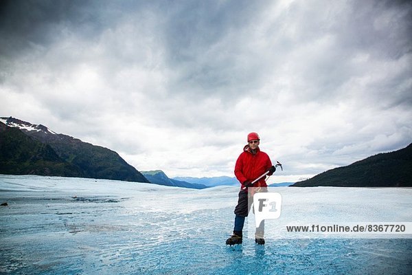Man with ice pick on Mendenhall Glacier  Alaska  USA