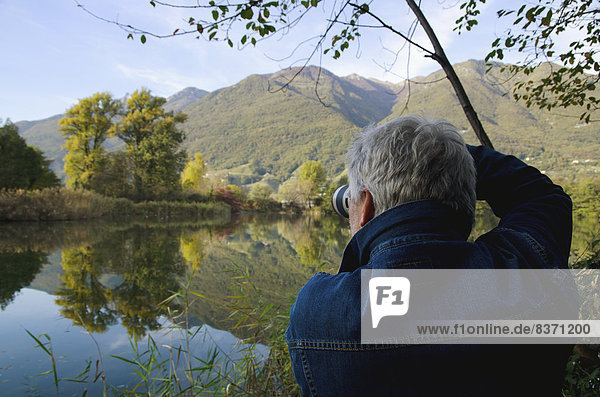 A Man Photographs Scenery Across A Tranquil Lake Locarno  Ticino  Switzerland