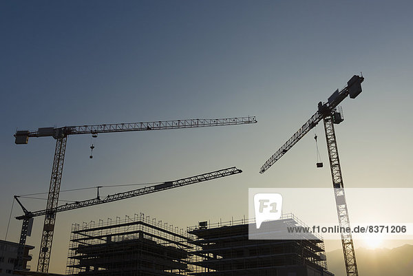 Silhouette Of Cranes And Frames Of Buildings Under Construction At Sunset Locarno  Ticino  Switzerland
