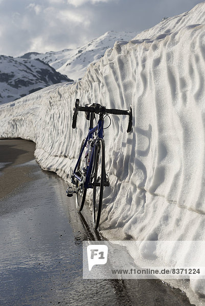 A Bicycle Leaning Against A Wall Of Snow In A Mountain Pass San Gottardo  Uri  Switzerland
