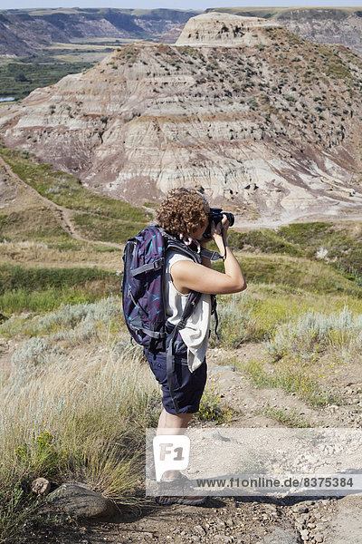 A Woman Photographs The Badlands Drumheller  Alberta  Canada
