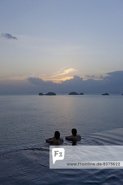 Two People At The Edge Of An Infinity Pool Enjoying The Sunset  Ko Samui  Thailand