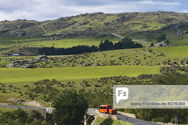 A Bus Drives Down A Scenic Stretch Of Road Just Outside Of Hyde In New Zealand's Otago Region  New Zealand