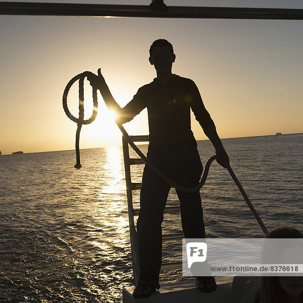 stehend  Mann  Ecke  Ecken  Sonnenuntergang  Seil  Tau  Silhouette  Boot  Bay islands  Honduras
