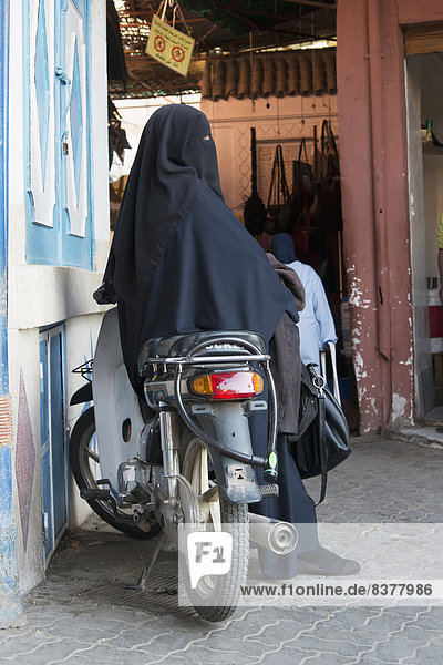 Außenaufnahme  sitzend  Frau  parken  Laden  Kleidung  Motorrad  Hidschab  Marokko