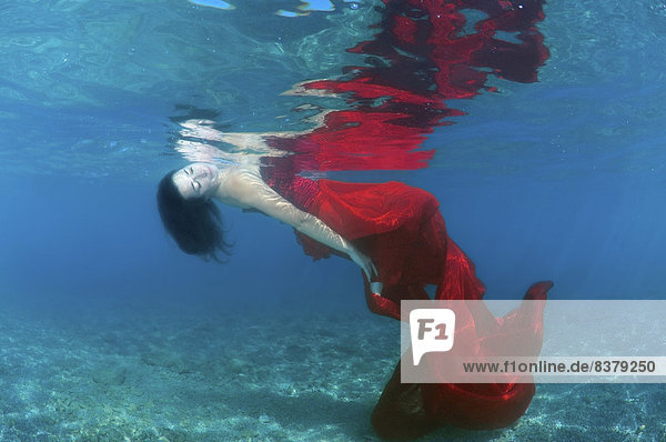 Underwasser-Model im Abendkleid im Meer  Griechenland