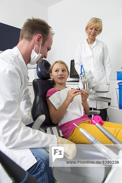 Mädchen beim Zahnarzt  der Zahnarzt bespricht die weitere Behandlung mit ihr  Deutschland
