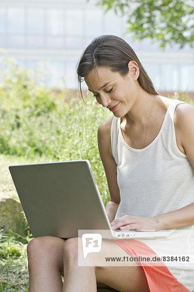 Frau mit Laptop im Freien