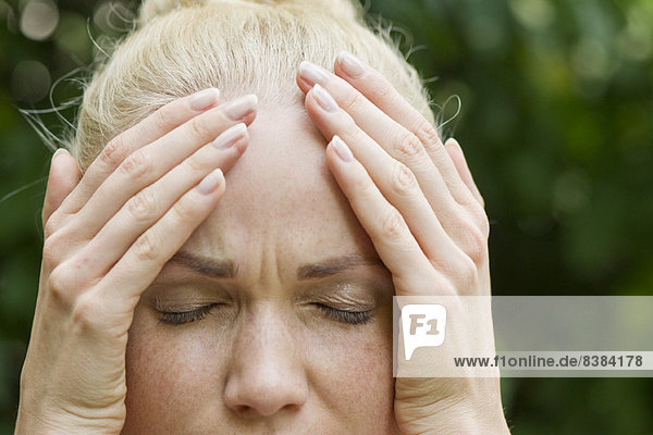 Woman holding head with distressed expression