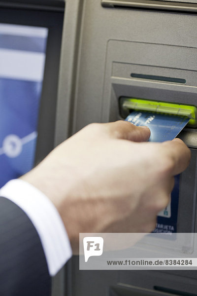 Einsetzen der Bankkarte in ATM,  um automatisierte Bankgeschäfte durchzuführen