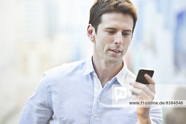 Mid-adult man checking cell phone  portrait