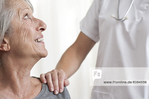 Woman being comforted by healthcare professional  cropped