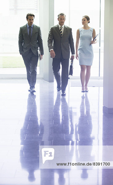 Business people walking in office lobby