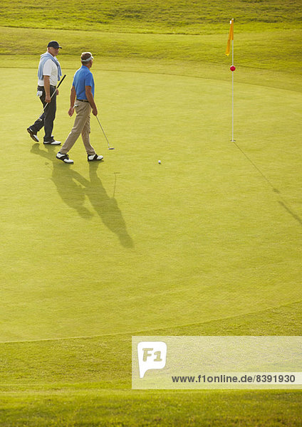 Senior men walking on golf course