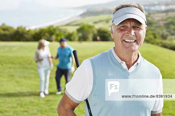 Lächelnder älterer Mann auf dem Golfplatz