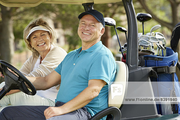 Senior couple smiling in golf cart