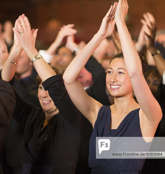 Enthusiastic women clapping in theater audience