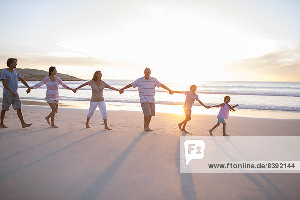 Family holding hands on beach