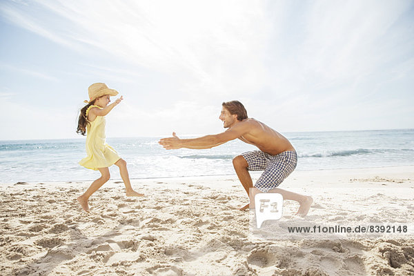 Father and daughter playing on beach