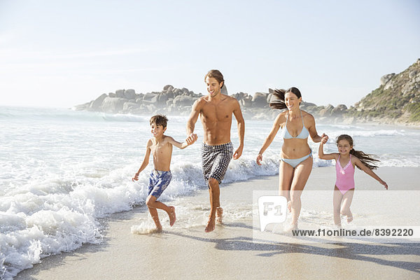 Family running together in waves