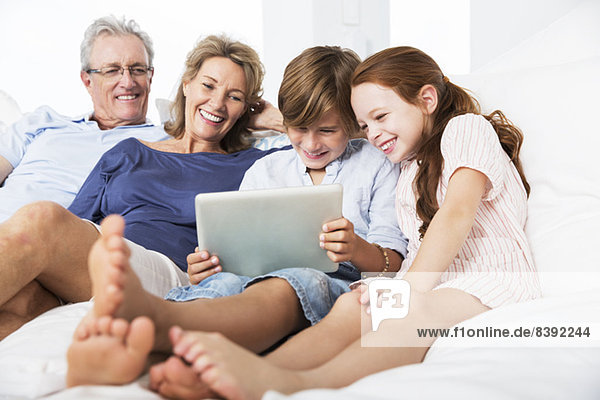 Ältere Paare und Enkelkinder mit digitalem Tablett