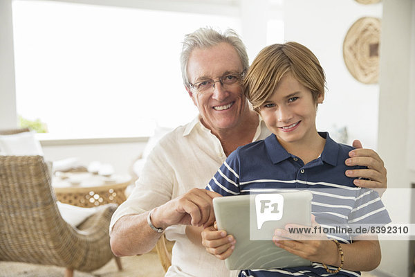 Älterer Mann und Enkel mit digitalem Tablett