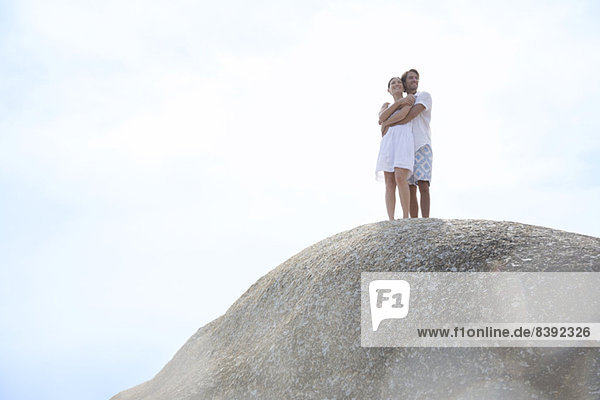 Couple hugging on rock formation