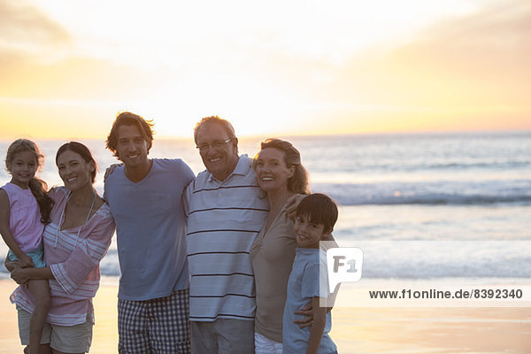 Familie lächelt zusammen am Strand