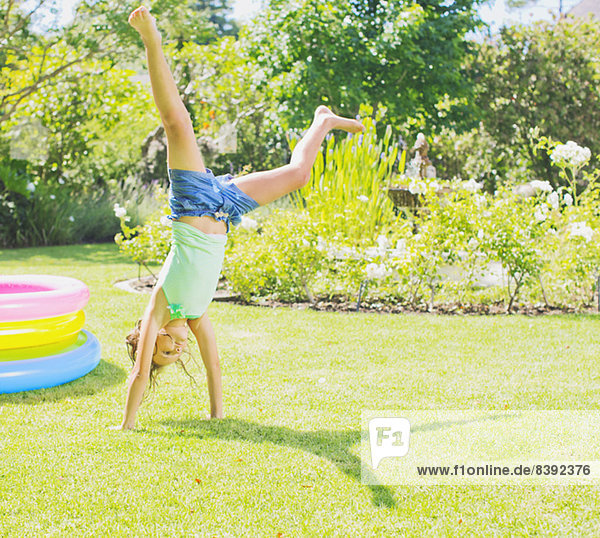 Girl doing cartwheels in backyard
