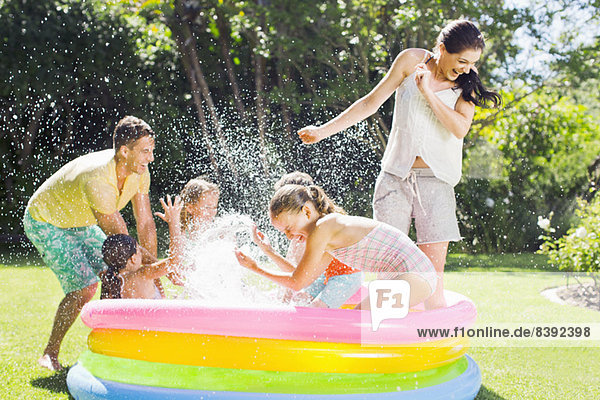 Family playing together in wading pool