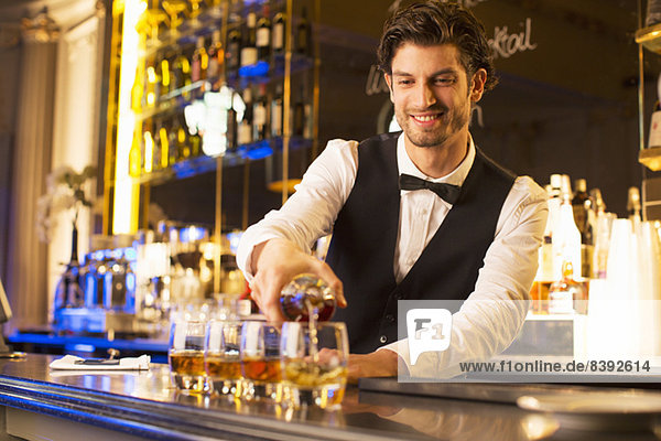 Gut gekleideter Barkeeper mit Bourbon an der Luxusbar