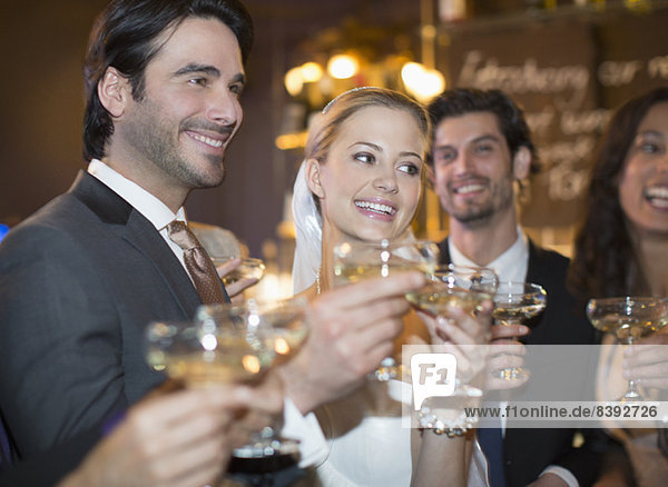 Close up of bride and groom toasting champagne glasses