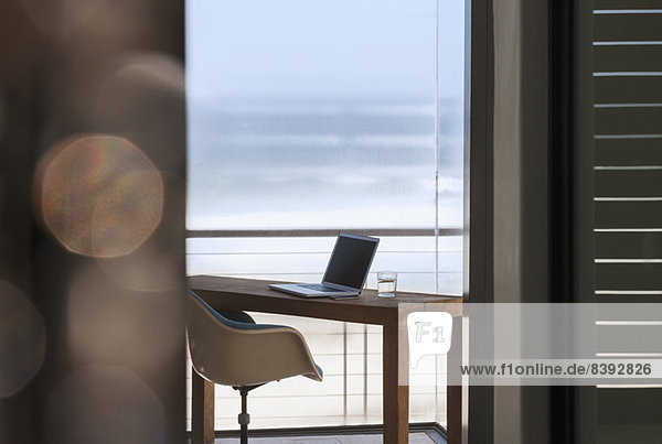 Laptop auf dem Schreibtisch im modernen Home-Office mit Blick aufs Meer