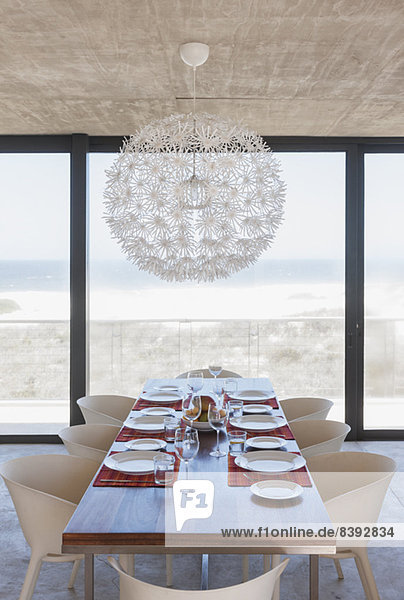 Gedeckter Tisch im modernen Esszimmer mit Blick auf den Ozean