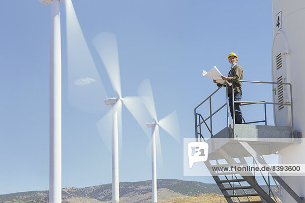 Arbeiter auf einer Windkraftanlage in ländlicher Landschaft stehend