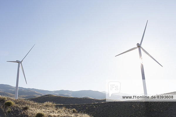 Windkraftanlagen drehen sich in ländlicher Landschaft