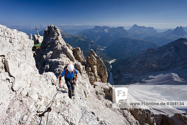 Mountain climber ascending the Via Ferrata Marino Bianchi climbing route on Cristallo di Mezzo Mountain  Dolomites  Belluno  Italy