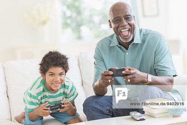 Boy playing video games with grandfather