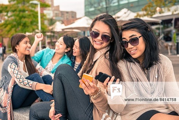 Junge Frauen schauen auf Smartphones
